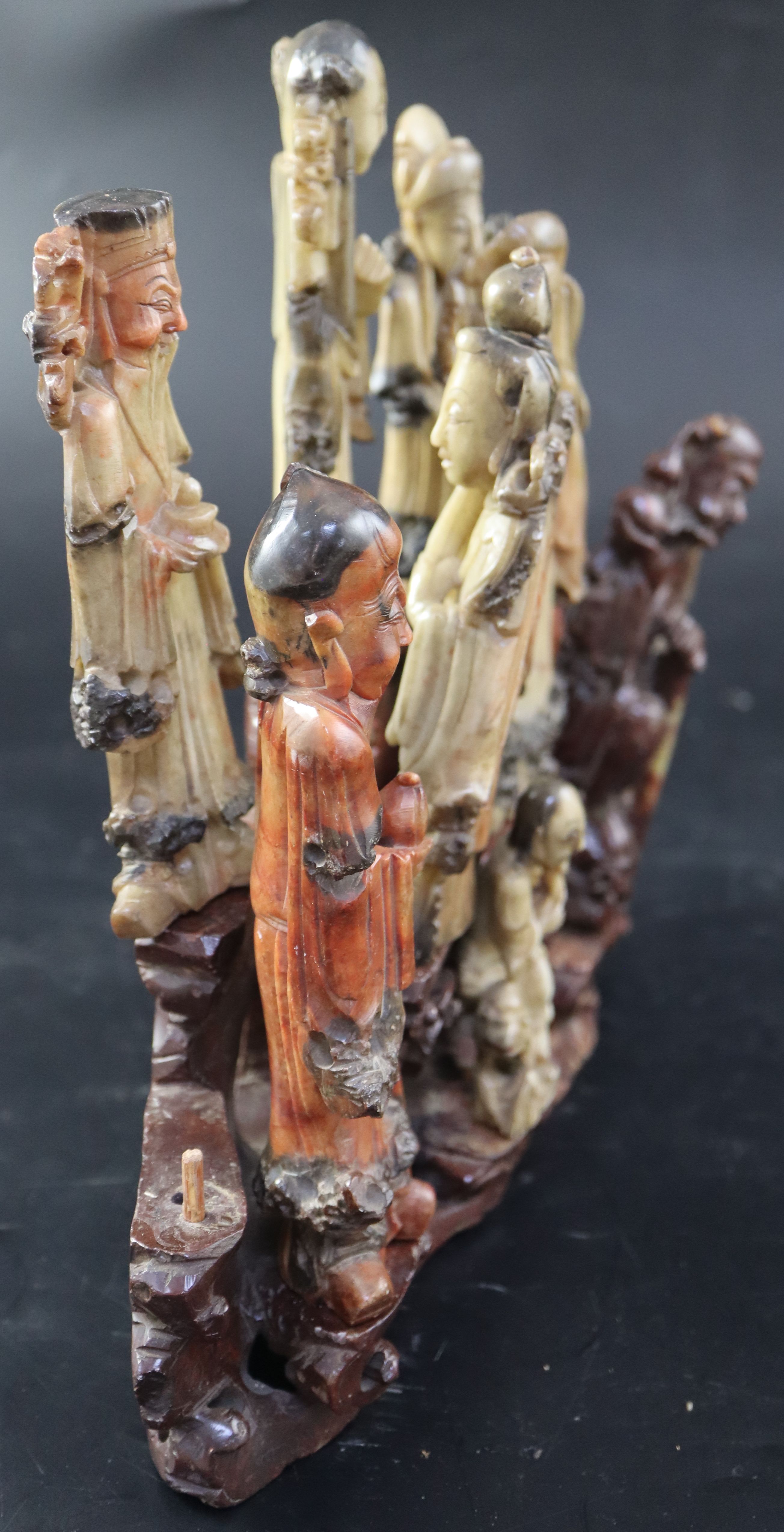 A group of nine Chinese Taoist carved coloured soapstone figures of immortals, width 29cm height 27cm